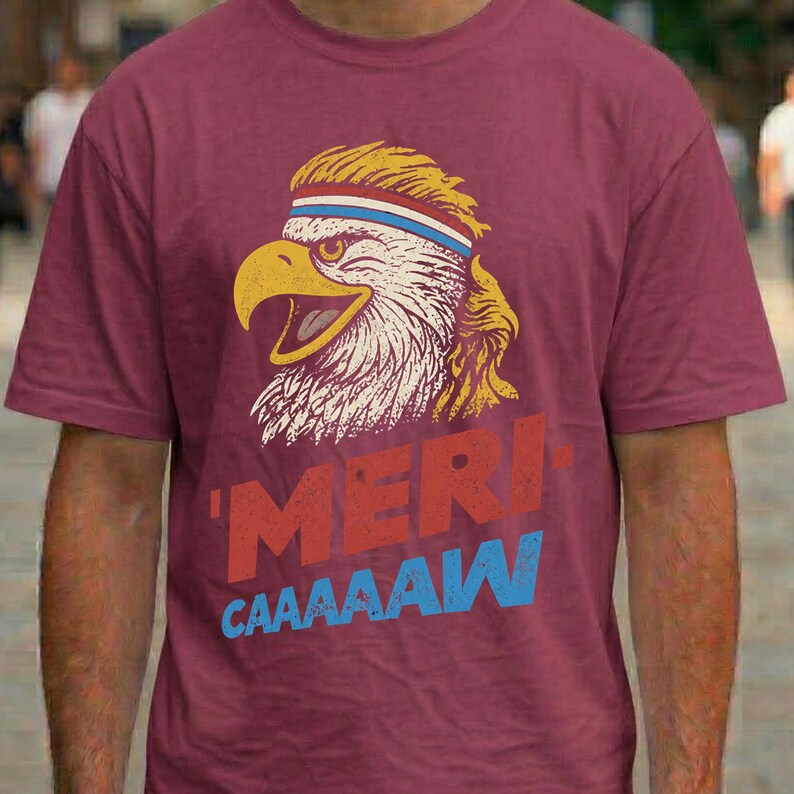 Distressed retro graphic featuring a bald eagle with a squawking open yellow beak and a blonde mullet haircut. The eagle wears a red, white, and blue striped athletic sweatband. Below the illustration, large weathered block text reads "'MERI-" in red, stacked above "CAAAAAW" in bright blue.