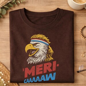 Distressed retro graphic featuring a bald eagle with a squawking open yellow beak and a blonde mullet haircut. The eagle wears a red, white, and blue striped athletic sweatband. Below the illustration, large weathered block text reads "'MERI-" in red, stacked above "CAAAAAW" in bright blue.