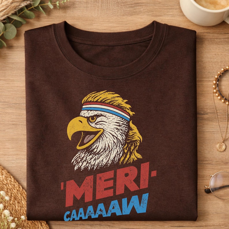Distressed retro graphic featuring a bald eagle with a squawking open yellow beak and a blonde mullet haircut. The eagle wears a red, white, and blue striped athletic sweatband. Below the illustration, large weathered block text reads "'MERI-" in red, stacked above "CAAAAAW" in bright blue.