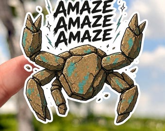 Könnte beinhalten: Ein Aufkleber mit einer stilisierten Krabbe mit einer braunen und türkisfarbenen steinartigen Textur. Das Wort "AMAZE" wird dreimal in fetter, schwarzer Schrift über der Krabbe wiederholt. Der Aufkleber hat einen weißen Rand und ein cartoonartiges Design.