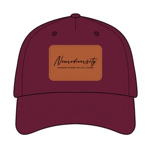 May include: A maroon baseball cap with a curved brim. A rectangular patch on the front displays the word "Neurodiversity" in cursive, with the text "UNIQUE MINDS OF ALL KINDS" below it. The cap has a structured crown and a button on top.