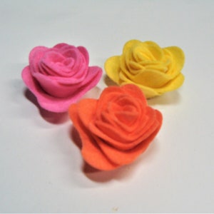 May include: Three felt roses in vibrant colors: hot pink, yellow, and orange. Each rose is crafted with layered petals, creating a realistic floral design. These decorative flowers are ideal for crafts and embellishments.
