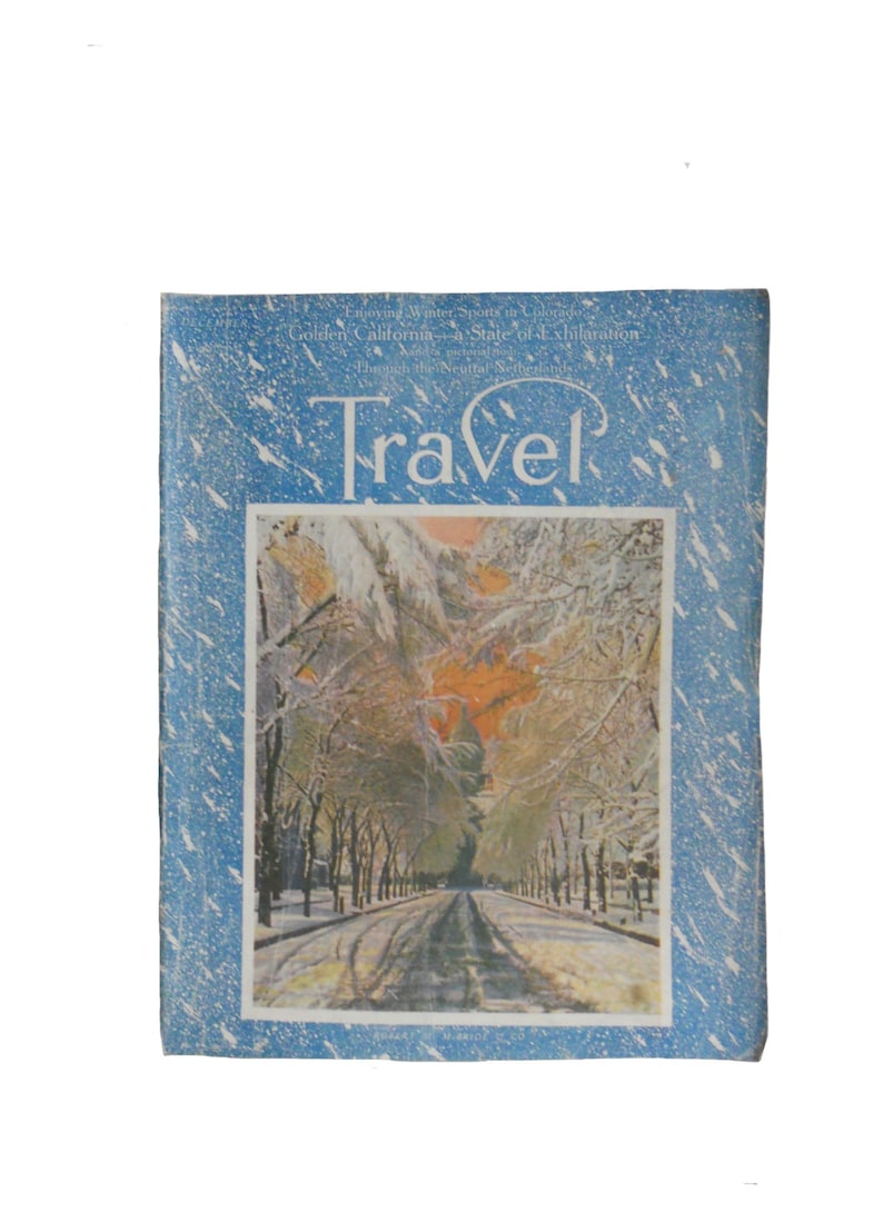 Pu&ograve; includere: Una copertina di rivista vintage che mostra una scena invernale innevata con una strada fiancheggiata da alberi. La rivista si chiama "Travel" e il testo "Enjoying Winter Sports in Colorado, Golden California - A State of Exhilaration, Through the Neutral Netherlands" &egrave; visibile.