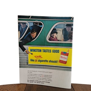 Op de afbeelding: Een vintage advertentie voor Winston-sigaretten met een bus met passagiers die uit de ramen kijken. De advertentietekst luidt "Winston tastes good, your like a cigarette should!" en "So change to Winston and change for good - for good taste."