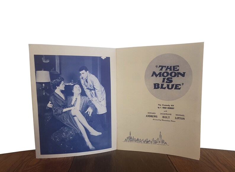 May include: A black and white photo of a playbill for the comedy "The Moon is Blue" by F. Hugh Herbert. The playbill features the names of the actors: Seward Andrews, Jacqueline Bolt, and Michael Lipton. The playbill is set against a backdrop of a city skyline.