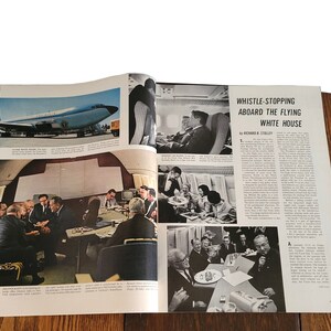 Op de afbeelding: Een zwart-witfoto van een magazine spread over het "Vliegende Witte Huis". Het artikel is getiteld "Whistle-Stopping Aboard the Flying White House" door Richard B. Stillley. Het artikel bevat foto's van het interieur van het vliegtuig, waaronder een vergadering in een vergaderruimte, een groep mensen die eten en een groep mensen die op stoelen zitten.