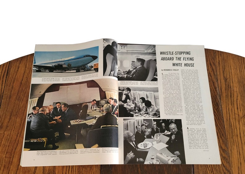 Op de afbeelding: Een zwart-witfoto van een magazine spread over het "Vliegende Witte Huis". Het artikel is getiteld "Whistle-Stopping Aboard the Flying White House" door Richard B. Stillley. Het artikel bevat foto's van het interieur van het vliegtuig, waaronder een vergadering in een vergaderruimte, een groep mensen die eten en een groep mensen die op stoelen zitten.