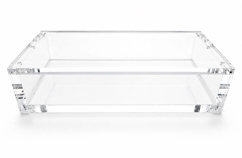 Puede incluir: Una bandeja rectangular de acr&iacute;lico transparente con una base plana y cuatro lados verticales. La bandeja presenta juntas estructurales visibles en cada esquina, construida con material transparente e incoloro con un acabado liso y pulido.