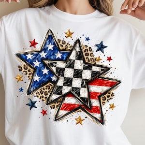 May include: White t-shirt featuring a graphic design of three stars. One star has a blue and white pattern, another has a black and white checkered pattern, and the third has a red and white striped pattern. Additional gold, red, and blue stars are scattered around.