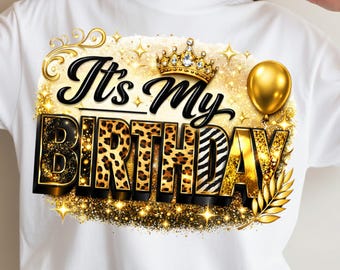 May include: White t-shirt featuring a gold and black graphic that reads "It's My Birthday." The design includes a crown, a balloon, and leopard and zebra print lettering. The shirt is decorated with gold glitter.