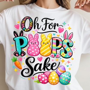 May include: White t-shirt with a colorful Easter design. The design includes the phrase "Oh For Peeps Sake" in black script, along with cartoon bunnies, Easter eggs, and a carrot. The letters are decorated with floral and patterned designs.