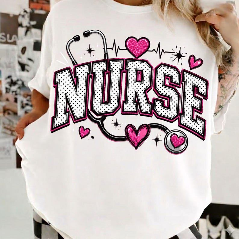 Puede incluir: Una camiseta blanca con la palabra NURSE en letras grandes de bloque con contorno negro y puntos blancos. El dise&ntilde;o incluye un estetoscopio negro, varios corazones rosas brillantes y peque&ntilde;os detalles de estrellas en el pecho.