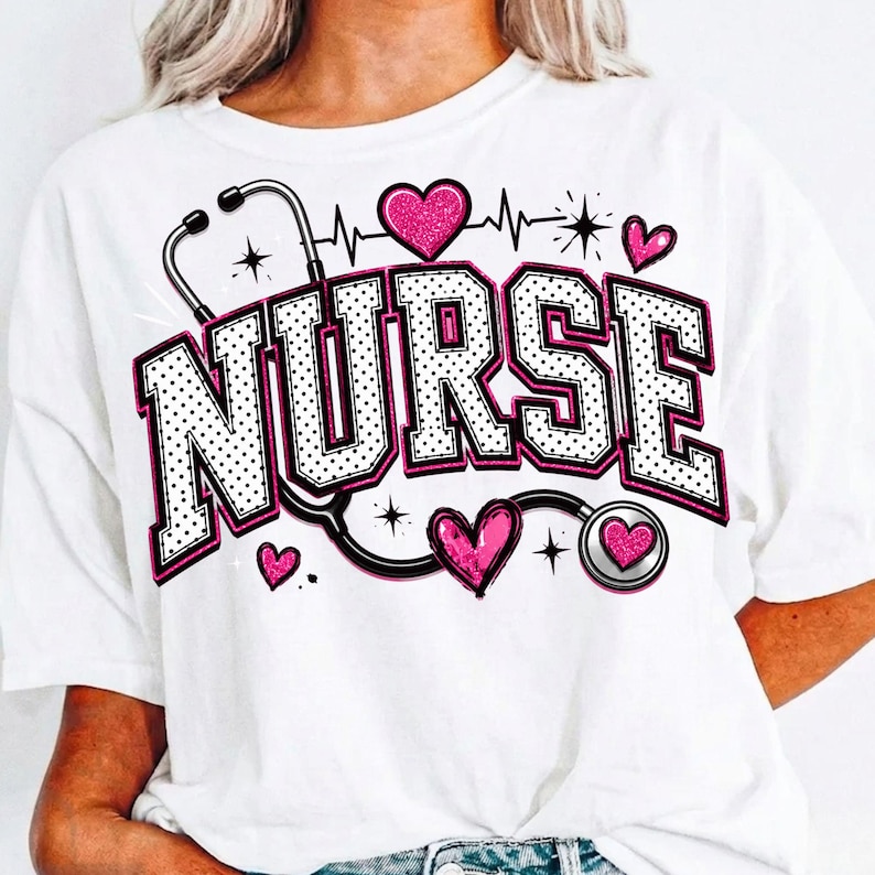 Puede incluir: Una camiseta blanca con la palabra NURSE en letras universitarias grandes, blancas con puntos y contorno negro. El dise&ntilde;o incluye un gr&aacute;fico de estetoscopio negro, varios corazones rosas brillantes y una l&iacute;nea de latido.