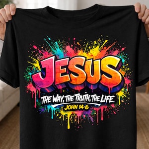 May include: Black t-shirt featuring the word "JESUS" in a graffiti-style design with vibrant colors. The shirt also includes the text "THE WAY, THE TRUTH, THE LIFE" and "JOHN 14:6".