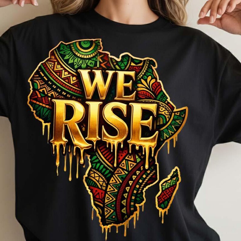 May include: Black t-shirt featuring a gold-colored outline of the African continent filled with colorful patterns. The words "WE RISE" are in gold, with a dripping effect. The design incorporates red, green, and yellow hues.
