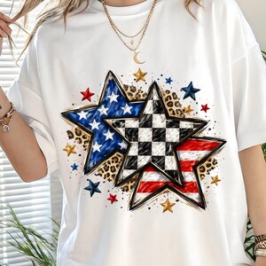 May include: White t-shirt featuring three star designs. One star has a blue and white pattern, another a black and white checkered pattern, and the third has red and white stripes. The stars are surrounded by smaller stars and leopard print.