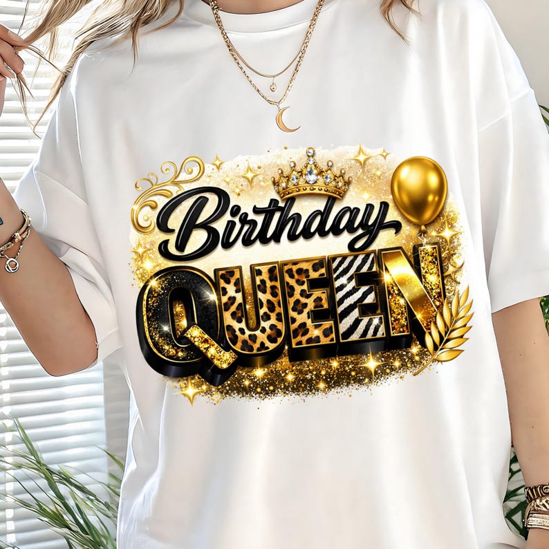 May include: White t-shirt with a gold and black "Birthday Queen" graphic. The design includes a crown, balloon, and leopard and zebra print letters. The shirt is a casual style.