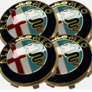 May include: A set of four circular Alfa Romeo emblems featuring a black outer ring with gold lettering, a red cross on a white background, and a green serpent graphic on a light blue field, all enclosed within a polished gold-colored metal border.