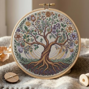 May include: A completed cross-stitch embroidery of a tree with roots, branches, and leaves, displayed in a wooden hoop. The tree features a detailed design with various colors, including brown, green, purple, and yellow. The embroidery is set against a neutral background.