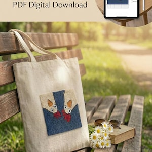 Op de afbeelding: Een beige draagtas met een kleurrijk kippen punch needle patroon. De tas ligt op een houten bank met een boek, zonnebril en bloemen. De tekst "Chicken Punch Needle Pattern PDF Digital Download" is zichtbaar.
