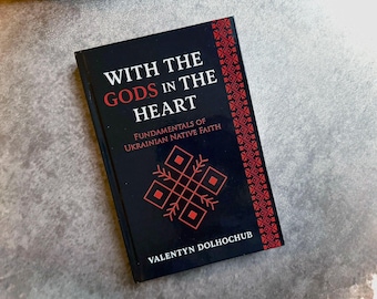 May include: A hardcover book titled "WITH THE GODS IN THE HEART" with the subtitle "Fundamentals of Ukrainian Native Faith." The cover is black with red text and a red geometric design. The author's name, Valentyn Dolhochub, is at the bottom.