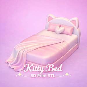 May include: A pink bed with a cat ear headboard, two pillows, and a heart-shaped pillow. The bed is covered with a pink blanket. The text "Kitty Bed" and "3D Print STL" are displayed on the bed.