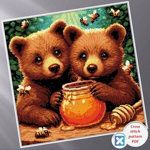 May include: A cross-stitch pattern featuring two brown bear cubs with honey and bees. The bears are holding a jar of honey and a honey dipper. The background is green and brown.