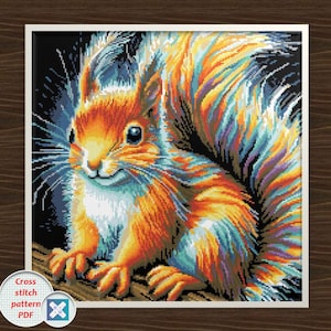May include: A colorful cross-stitch pattern of a squirrel. The squirrel has orange, blue, and white fur, with a fluffy tail. The image is framed in white and set against a dark background. The cross-stitch pattern is a PDF.