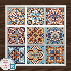 Peut inclure: Un motif de point de croix encadré présentant neuf carreaux carrés avec des motifs géométriques complexes. Les carreaux affichent une palette de bleu, d'orange et de jaune, créant une pièce vibrante et décorative. Le design rappelle les carreaux traditionnels.