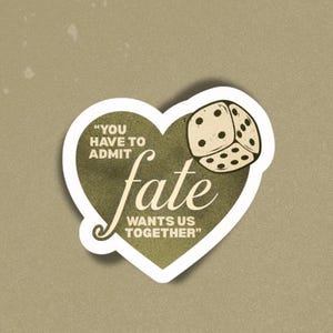 Könnte beinhalten: Ein herzförmiger Aufkleber mit dem Wort "fate" in einer stilisierten Schriftart und einem Würfel. Der Text lautet "You have to admit fate wants us together". Der Aufkleber ist mit "STICKER #3" beschriftet.