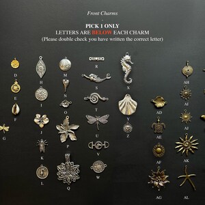May include: A collection of assorted metal charms in gold and silver tones, arranged in a grid with identifying letters. The text reads: Front Charms, PICK 1 ONLY, LETTERS ARE BELOW EACH CHARM, (Please double check you have written the correct letter).