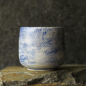 A handcrafted ceramic tea bowl featuring delicate sgraffito carving and matte glaze - minimalist yunomi cup