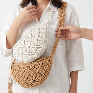 May include: Two macrame crossbody bags. One is off-white, the other is tan. Both have a geometric pattern and a zipper closure. The bags have adjustable straps and tassels. The bags are made of woven cotton.