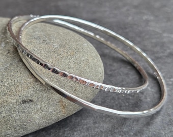 In elkaar grijpende zilveren armbandenset: duo-armband van gehamerd sterlingzilver