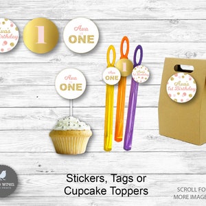 May include: A set of printable party decorations for a first birthday. The set includes cupcake toppers, stickers, tags, and a favor bag. The decorations feature a pink and gold color scheme with the name Ava and the number one.