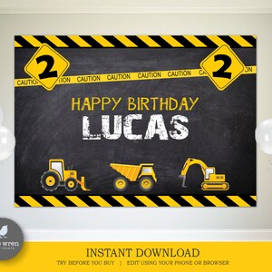 May include: A black chalkboard backdrop with yellow and black caution tape border. The text "HAPPY BIRTHDAY LUCAS" is written in white chalk. There are three yellow construction vehicles on the backdrop. The numbers "2" are on yellow diamond signs on either side of the backdrop.
