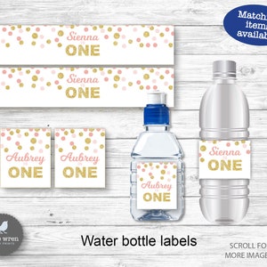 May include: Water bottle labels with a pink and gold confetti design. The labels feature the text "Sienna is One" and "Aubrey is One".