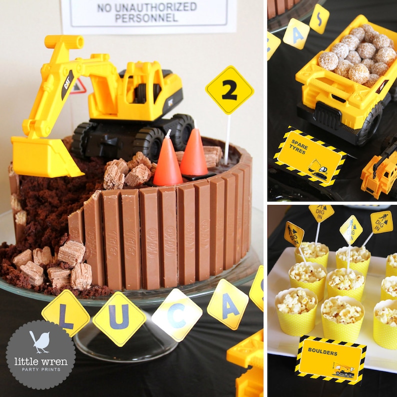 May include: A construction-themed birthday party with a chocolate cake decorated with a yellow toy excavator, chocolate bars, and orange traffic cones. The cake is on a glass cake stand with a yellow and black construction sign banner that says "LUCA". There are yellow and black construction signs with the words "DIG IN" and "SPARE TYRES". There are also yellow cups filled with popcorn and a yellow sign that says "BOULDERS".