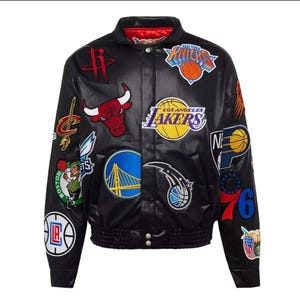 Pode incluir: Casaco bomber de cetim preto com vários logotipos de equipas, incluindo Lakers, Bulls e Knicks. O casaco tem gola e punhos vermelhos e cós canelado. Uma peça de roupa exterior elegante e desportiva.