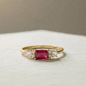 Anillo de oro macizo de 14 quilates con rubí de talla esmeralda y diseño de diamante en la piedra lateral. Joyería fina para mujer.