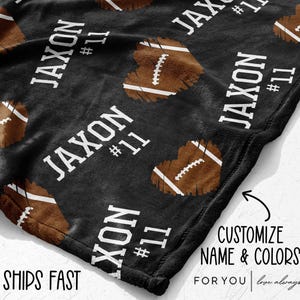 May include: Black blanket with a repeating pattern of brown football-shaped hearts and the name "JAXON" and the number "11" in white. The blanket has the text "CUSTOMIZE NAME & COLORS FOR YOU" and "SHIPS FAST".