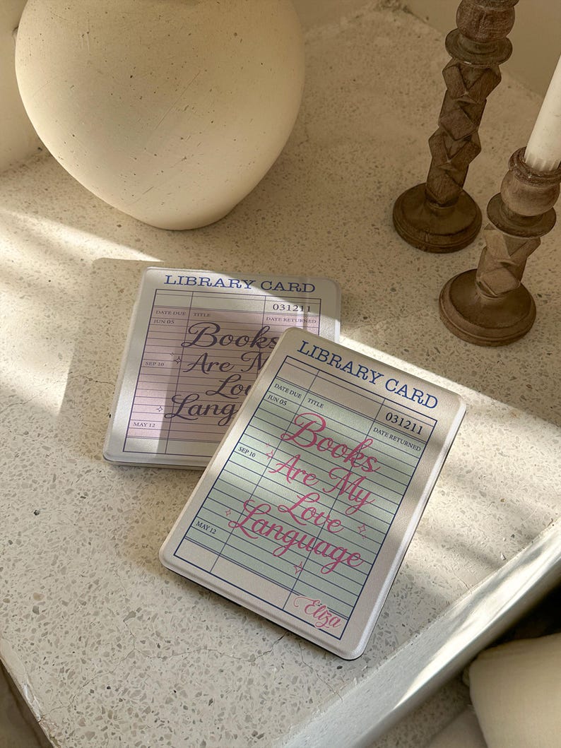 Books Are My Love Language library card Kindle case on a cozy coffee table with candle decor, vintage reader aesthetic cover for Kindle Paperwhite, personalized bookish Kindle case gift for readers and book lovers.