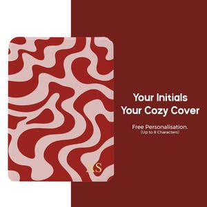 Puede incluir: Una funda roja y crema con un patr&oacute;n ondulado. La funda tiene esquinas redondeadas e iniciales doradas. El texto en la funda dice "Your Initials Your Cozy Cover" y "Free Personalisation. (Up to 8 Characters)". El logotipo de Bailey Creative Arts est&aacute; en la esquina superior derecha.