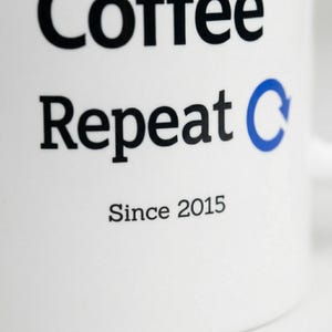 Close-up detail of the lower part of the “Code Coffee Repeat” mug design, showing the word “Repeat,” the blue circular arrow, and the personalized text “Since 2015”