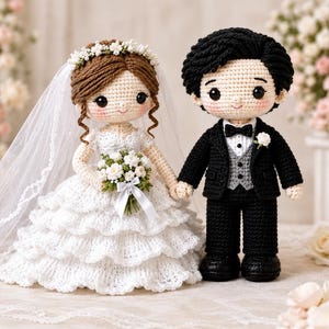 May include: Two crocheted dolls representing a wedding couple. The figure on the left wears a white tiered dress, a veil, and a floral crown, holding a small bouquet. The figure on the right wears a black suit, a grey vest, and a black bowtie.
