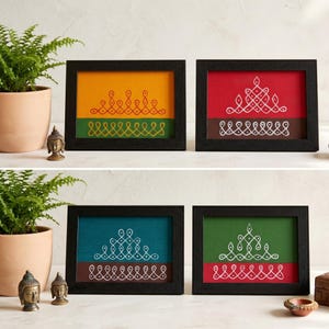May include: Four framed art pieces with black frames. Each features a colorful background with a geometric white design. The backgrounds are yellow, red, teal, and green. The art pieces are displayed on a white surface.