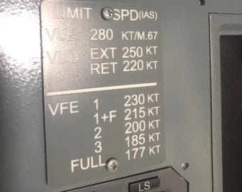 May include: A grey metal placard with white text detailing aircraft speed limits. It lists VLE 280 KT/M.67, VLO EXT 250 KT, VLO RET 220 KT, and VFE settings 1 through FULL with corresponding speeds from 230 KT to 177 KT. The plate is secured by two screws.
