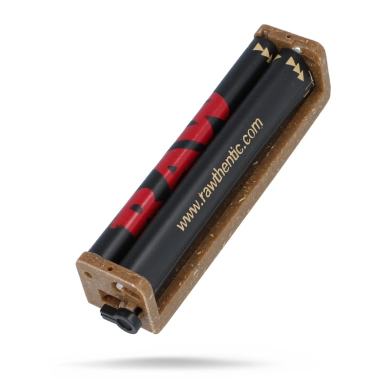 May include: A rectangular rolling machine with a textured tan frame and two black rollers. The rollers feature the red text RAW and the white text www.rawthentic.com printed on the surface. A small black plastic switch is located on the side.