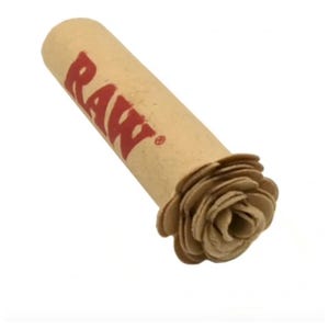 Puede incluir: Un producto de papel enrollado con la palabra "RAW" en letras rojas. El extremo del papel tiene forma de flor. El producto es de color marrón claro.