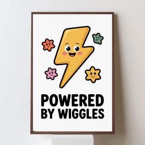 May include: A framed print featuring a smiling yellow lightning bolt with a face, surrounded by colorful star shapes. The text "POWERED BY WIGGLES" is printed in bold black letters below the lightning bolt.